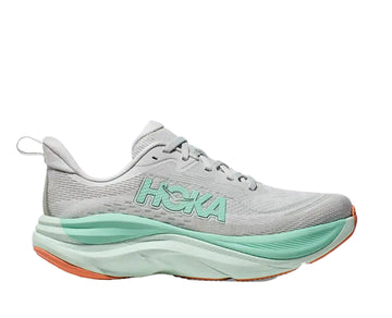 Gray running shoe with green sole and 'Hoka' branding on a white background