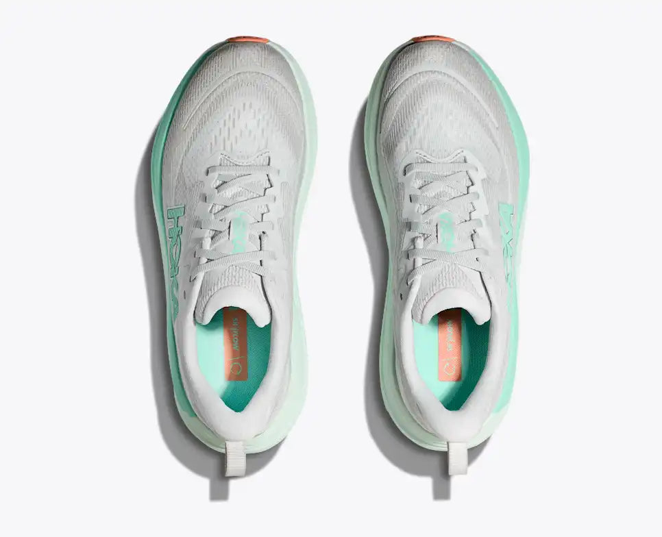 Gray running shoe with green sole and 'Hoka' branding on a white background
