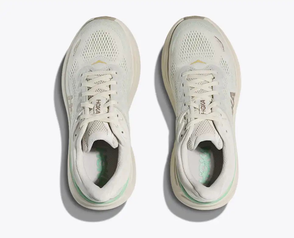White running shoe with green accents on a light gray background