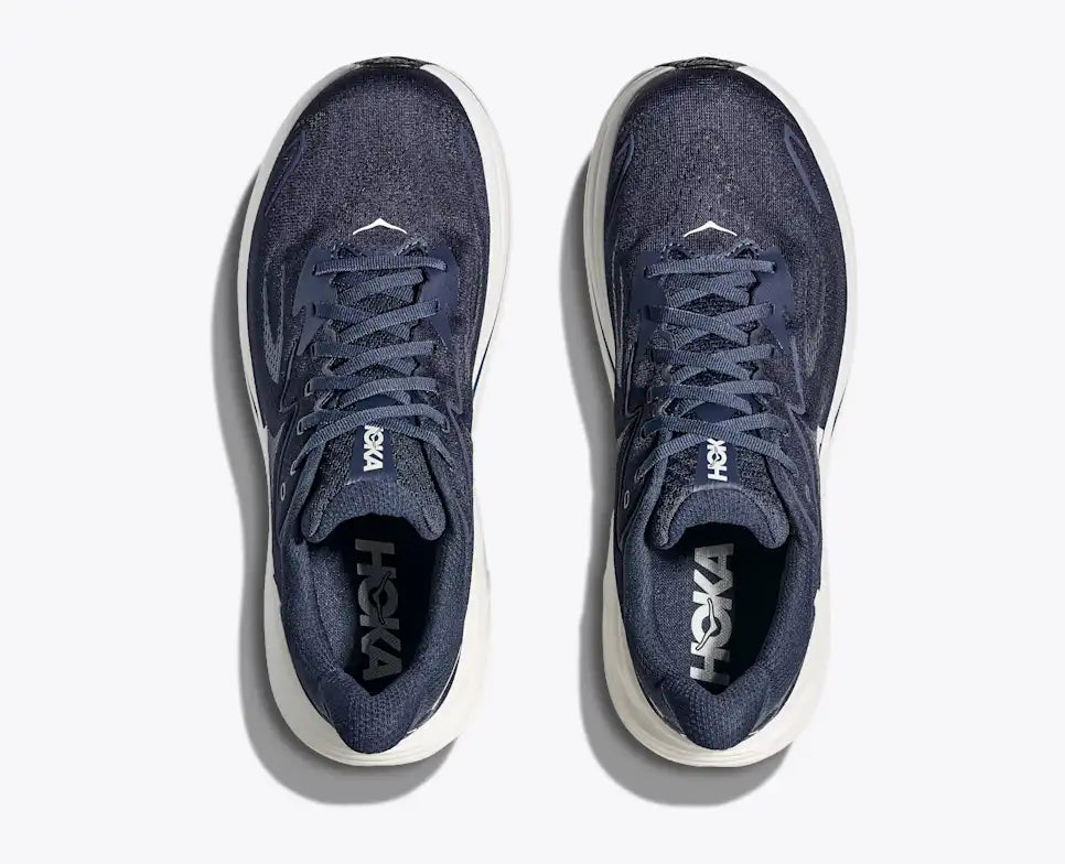 Navy running shoe with white sole on a white background