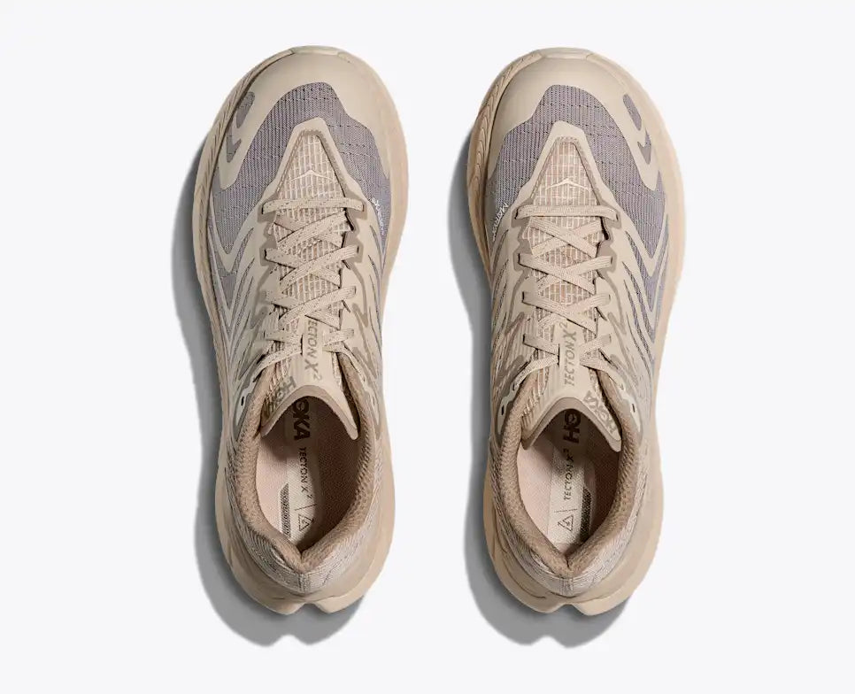 Beige running shoe with wavy pattern on a white background